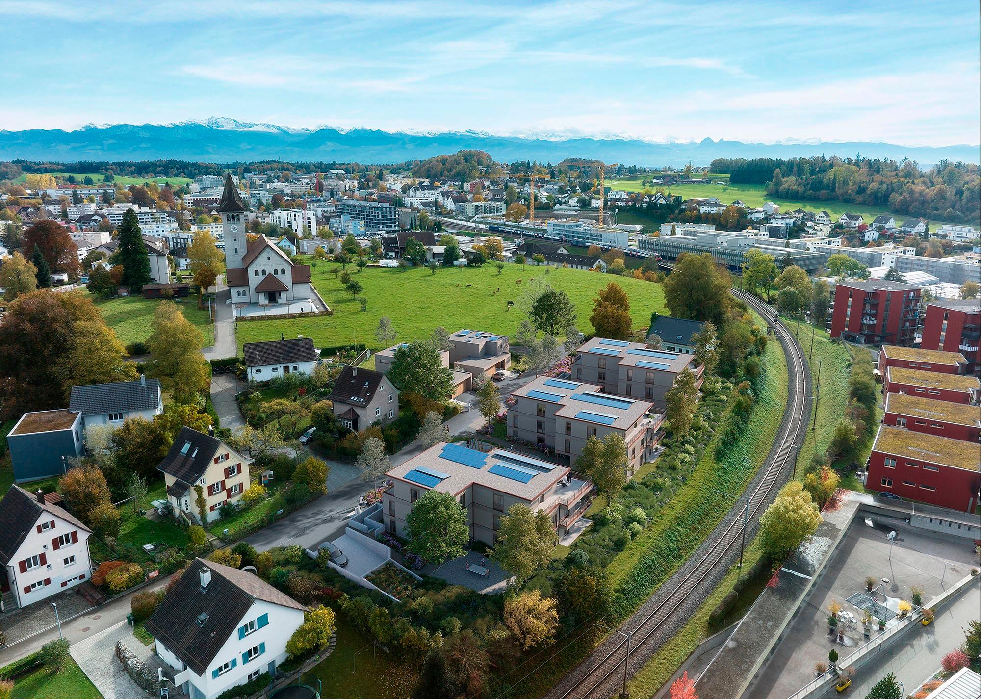 Luftaufnahme einer Stadt mit Alpenpanorama