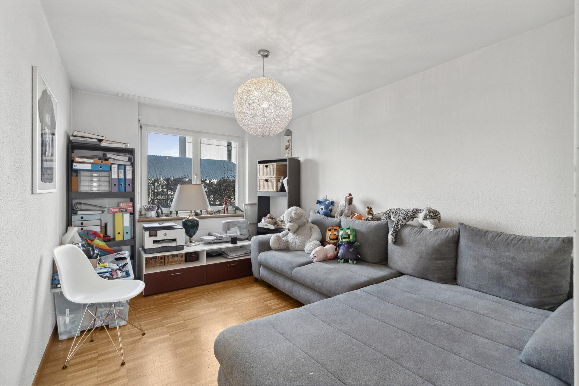 Helles Arbeits- und Wohnzimmer mit grauem Sofa