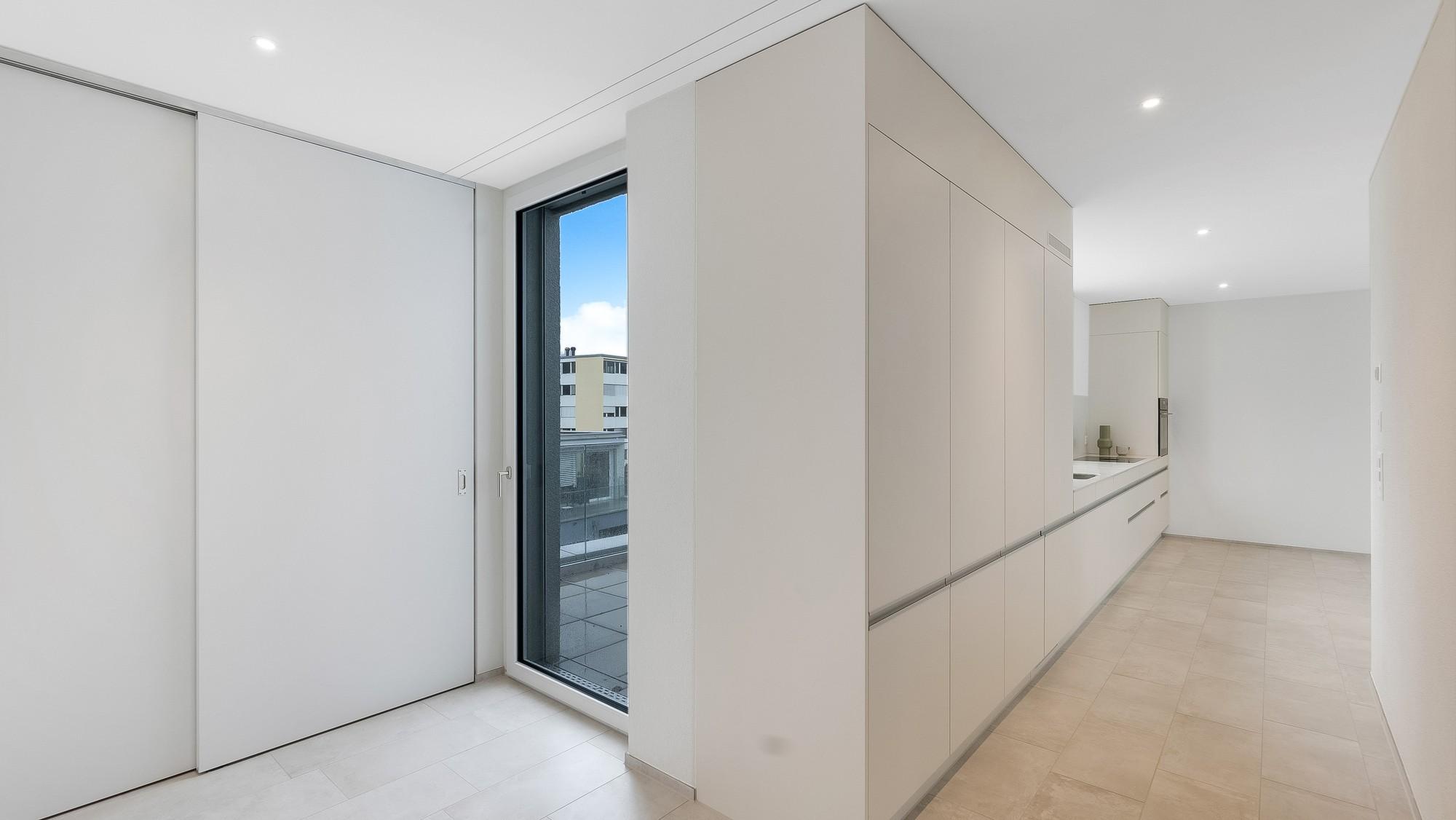 Heller, minimalistischer Flurbereich mit Einbauschränken und Fenster